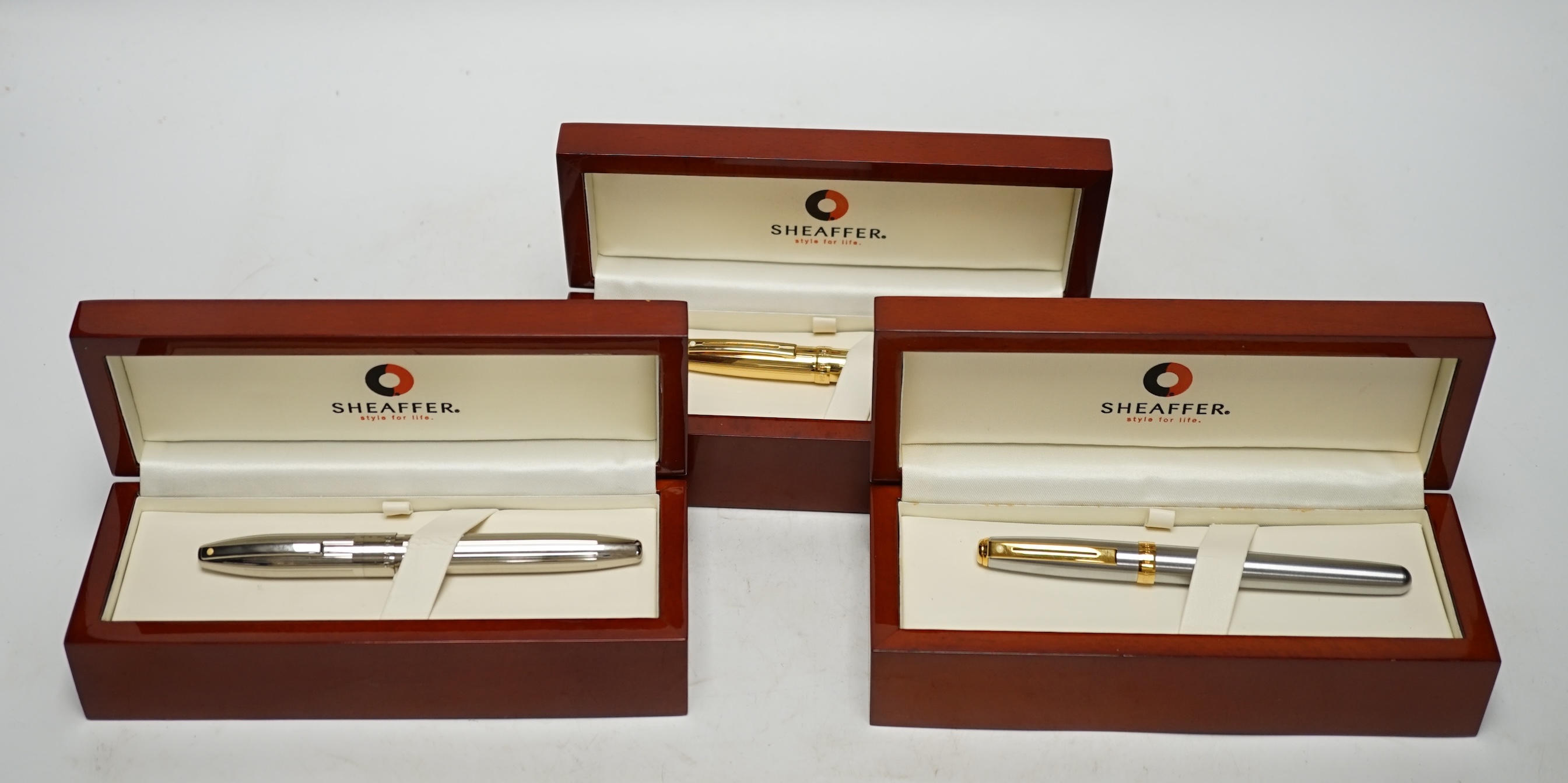 Three modern boxed Sheaffer fountain pens; an Imperial style pen and two others, all in stained beech cases